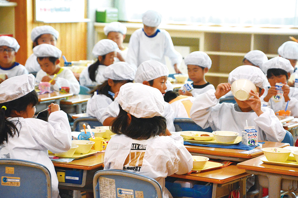学校で給食を食べる児童